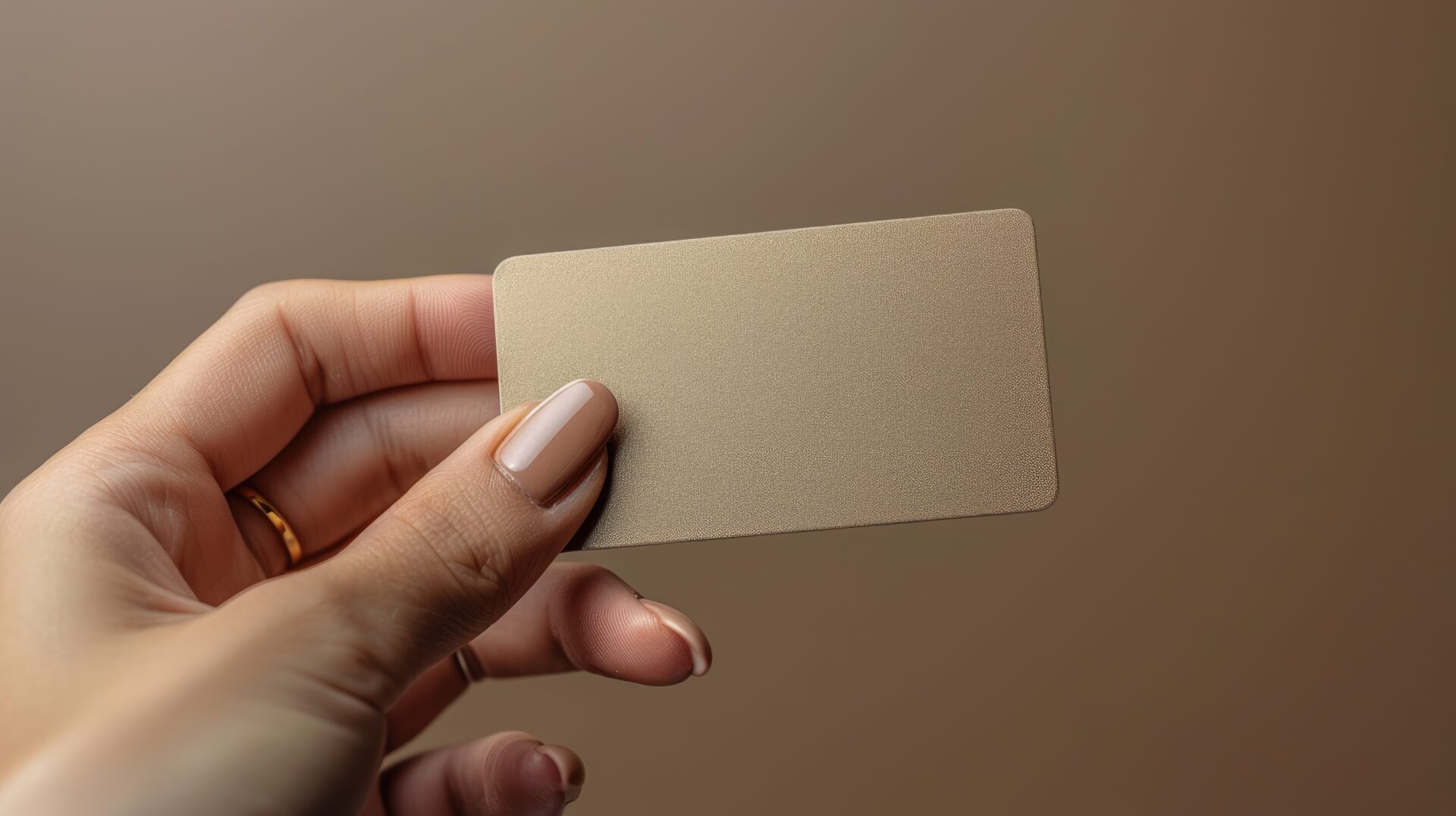 Hand holding a textured beige card